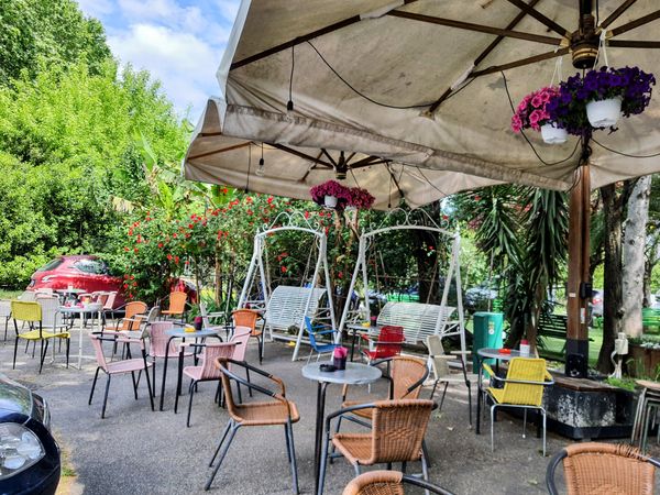 Morgenkaffee im Schatten grüner Ruhe, umgeben von lokalem Flair